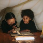 Two children read a book together under a cozy blanket fort, illuminated by soft lighting from Books Like Franklin the Turtle: 10 Best Read-Alike Series